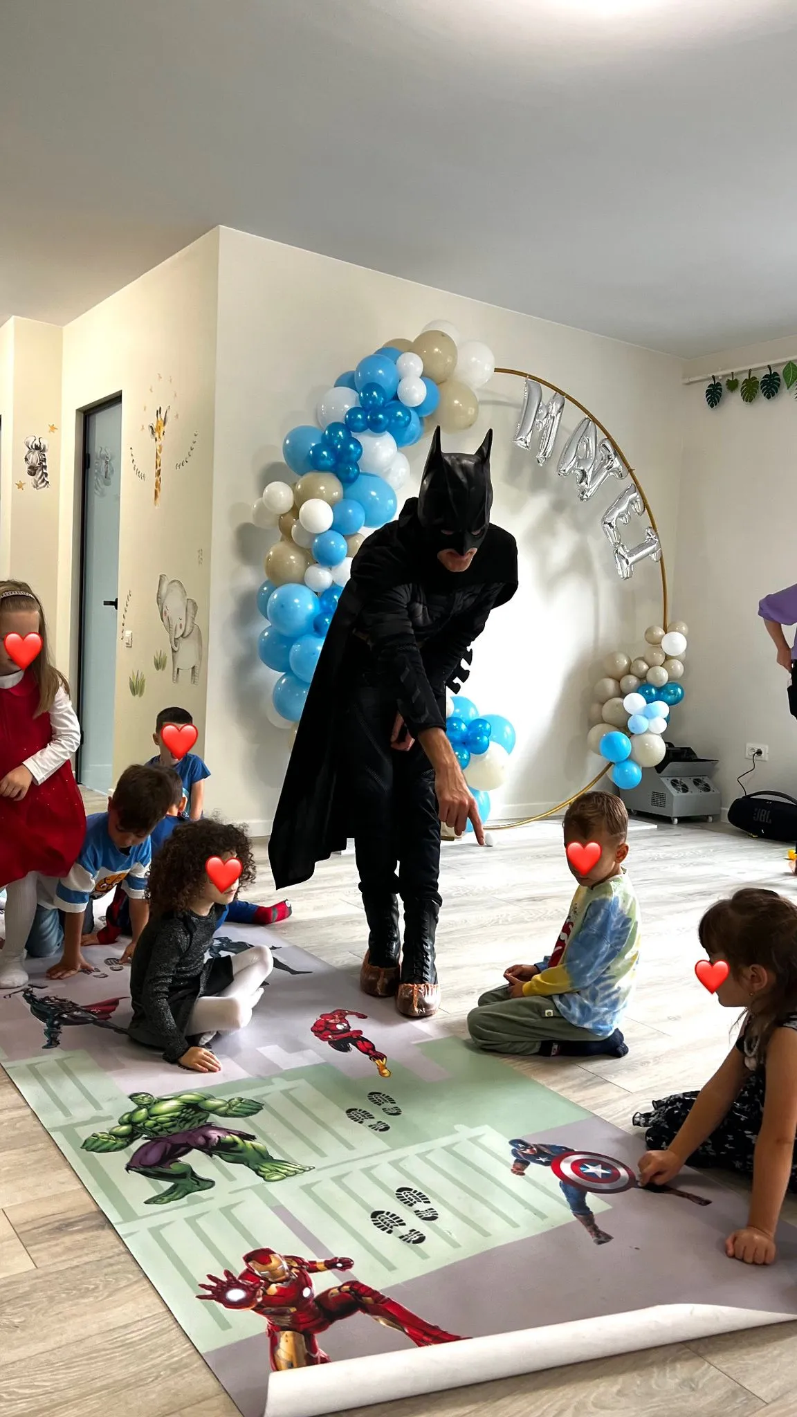 Mascota Batman jucandu-se cu cinci copii, in timpul unei petreceri