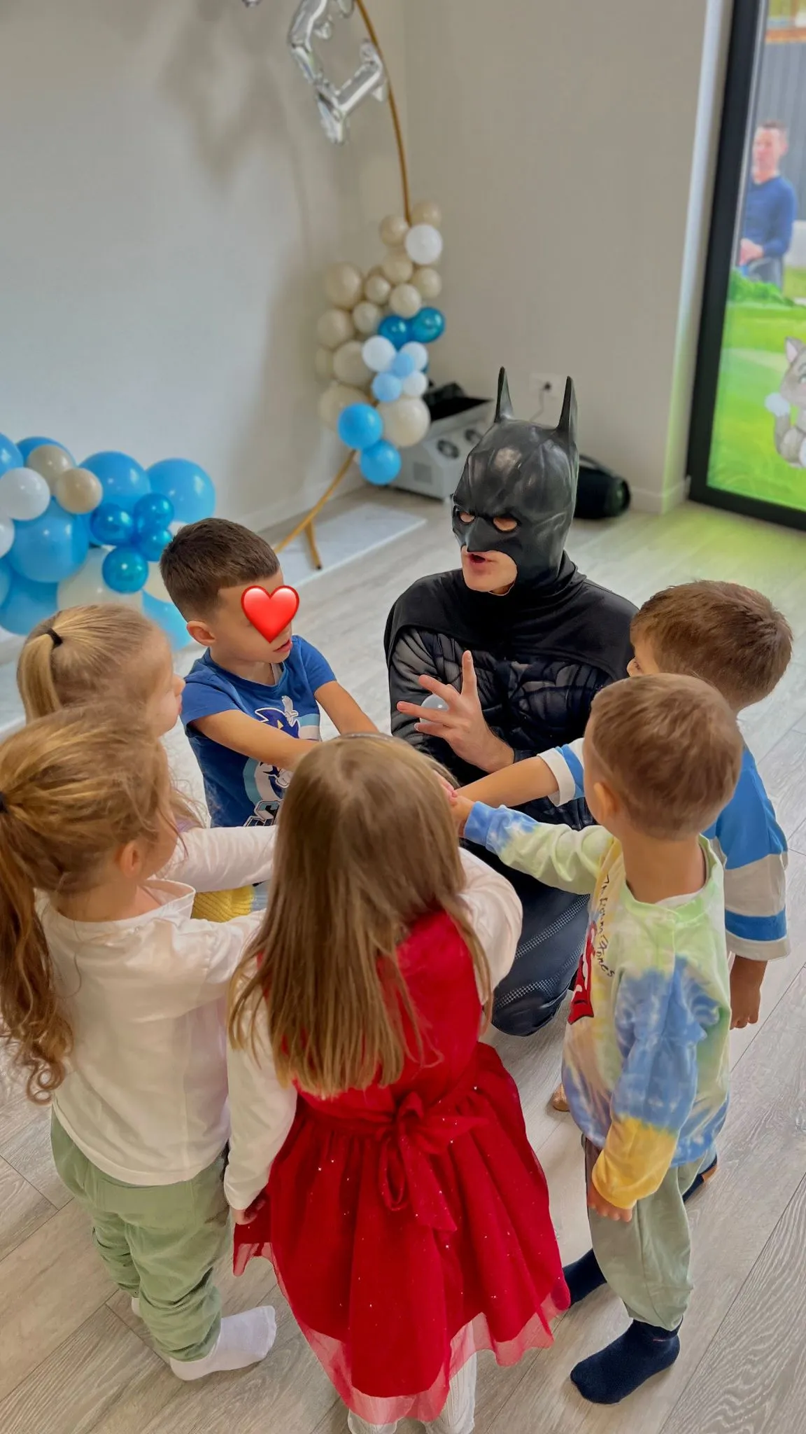 Mascota Batman impreuna cu sase copii, in timpul unei petreceri