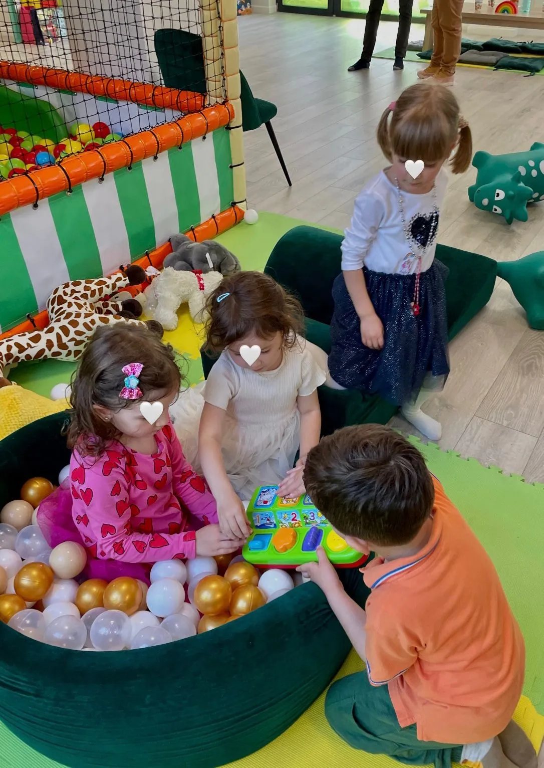 Patru copii jucandu-se in piscina de bile colorate, in timpul unei petreceri